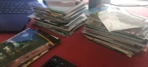 Stacks of photos being digitalized